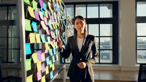 woman planning and brainstorming ideas on a sticky note board