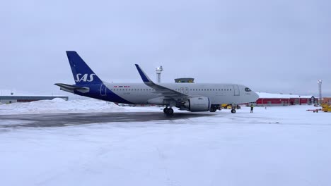 sas airbus a320 on the ramp of kiruna airport in the winter on a snowy ramp