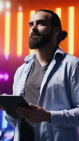 vertical video cool person standing beneath glowing neon lights surrounded by vibrant colors