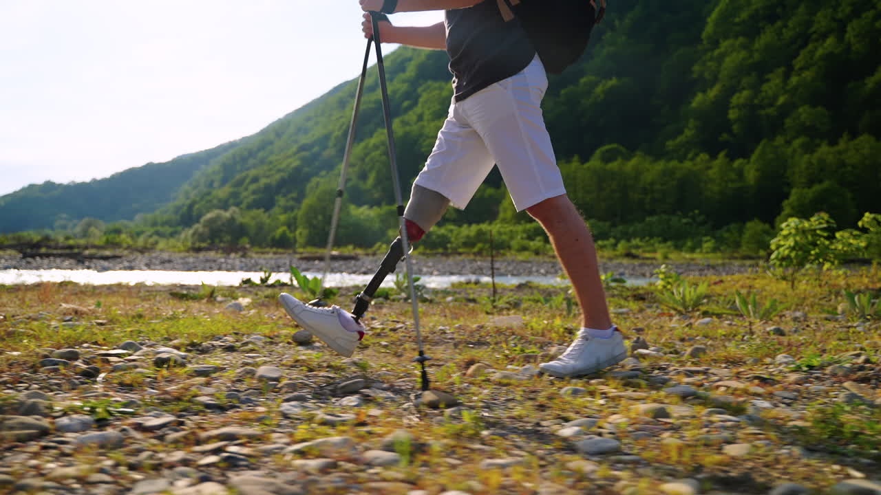 Persona con protesi alla gamba che fa escursioni in montagna