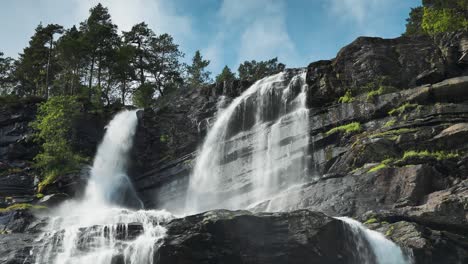 tvindefossen waterfall cascades from the dark rocky cliffs