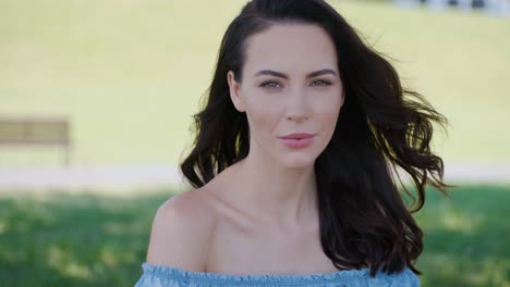 Beautiful-woman--fashion-model-with-long-brown-hair-sitting-on-green-grass