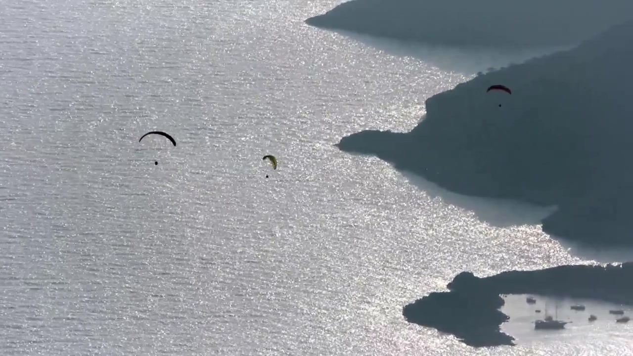 Paraglidingutøvere svever over det glitrende Middelhavet