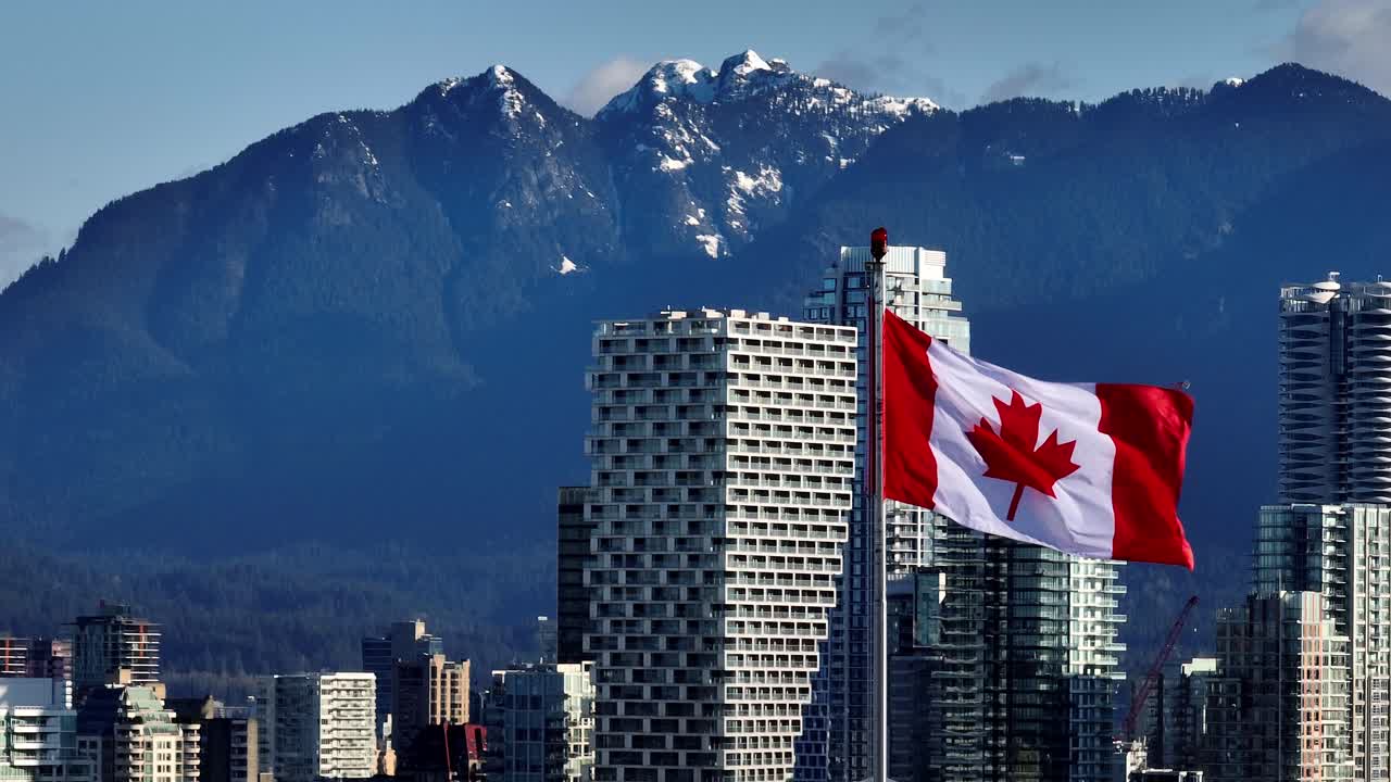 The Canadian Flag Soars Above the City as Downtown Vancouver and Distant Mountains Stretch Past South Granville, Vancouver, Canada - Zoom In Shot