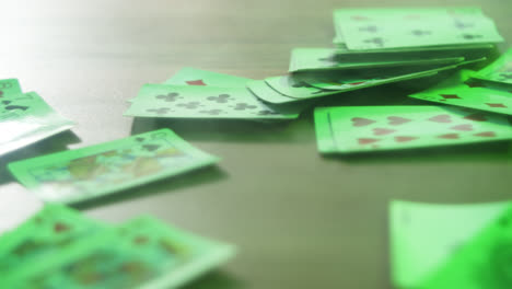 scattered playing cards on a green table