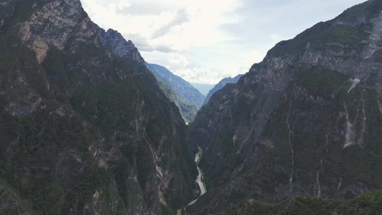 Rekaman udara menakjubkan yang memperlihatkan ngarai gunung yang dalam dengan sungai berkelok-kelok di bawahnya. Cocok untuk film dokumenter perjalanan, penceritaan lingkungan, dan tema keberlanjutan.
