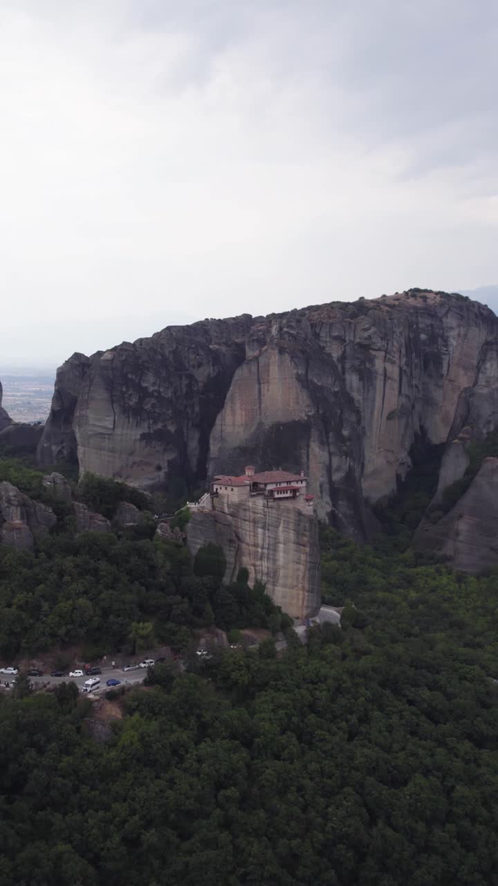 Vertical aerial shot of the Monastery of Rousanou perched on Meteora cliffs, highlighting the distinctive geological formations and rugged landscape