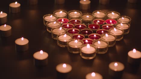 romantic red and white candles in the shape of a heart on black background 3