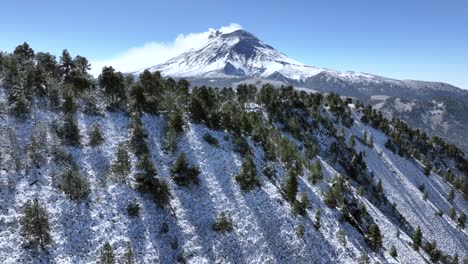 drone panoramic footage of the mountains in the center of mexico covered with snow, the popocatepetl volcano is visible in the background