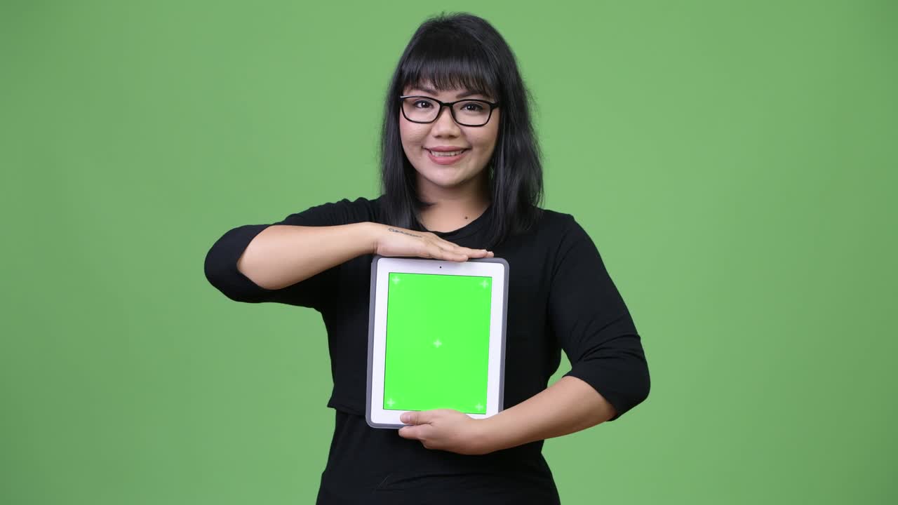 Smuk asiatisk forretningskvinde, der viser digital tablet