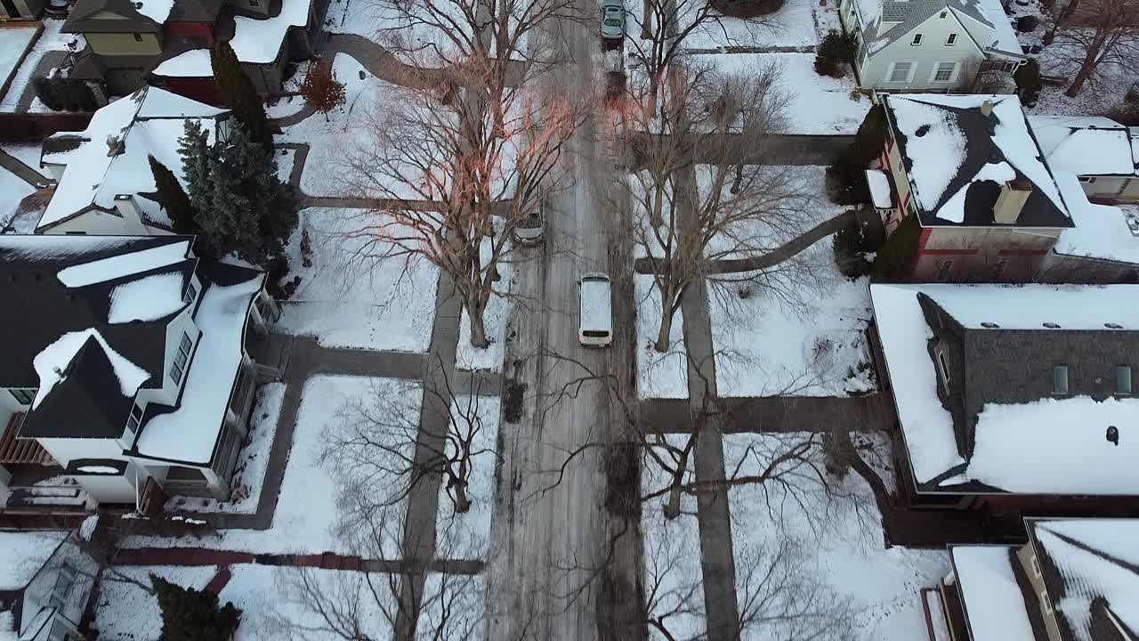 눈 덮힌 거리에서 집으로 향하는 표시가 없는 흰색 밴을 따라 맨 얼음 나무 끝의 일몰과 광선이 있는 겨울 고급 주거 주택 지역 황혼에 2-4개의 공중 돌리 롤