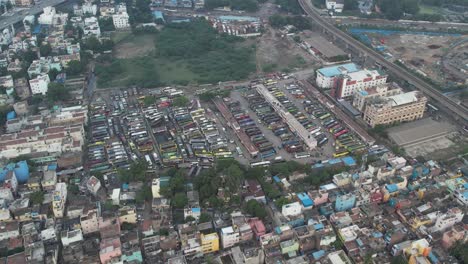 Vista-Aérea-De-La-Estación-De-Autobuses-Privada-En-La-Terminal-De-Autobuses-Mofussil-De-Chennai,-Cerca-Del-Mercado-De-Verduras-De-Koyambedu.