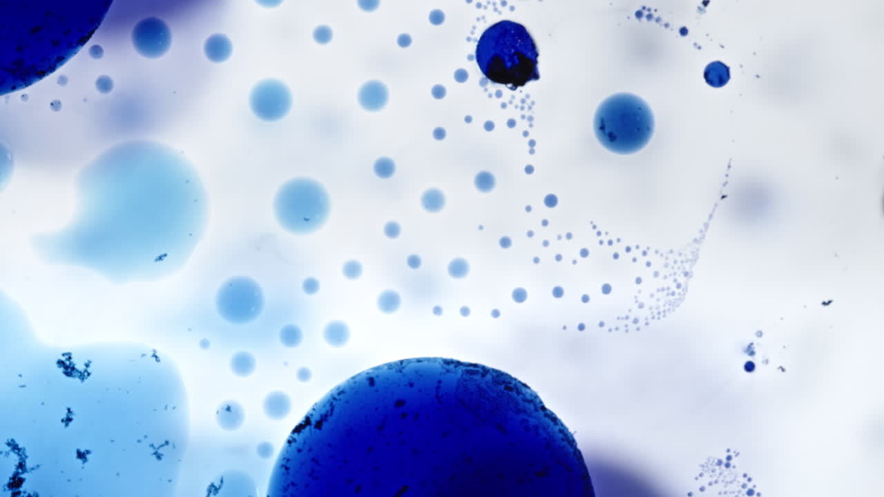 Blue alcohol ink bubbles creating hypnotic macro patterns in fluid abstract motion