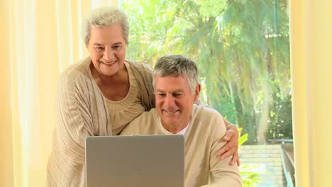 Älteres-Paar-Lächelt-über-Etwas-Auf-Einem-Laptop