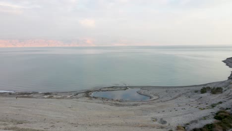 Aerial-fly-over-a-water-pond-by-the-Dead-Sea,-Drone-wide-shot,-Israel