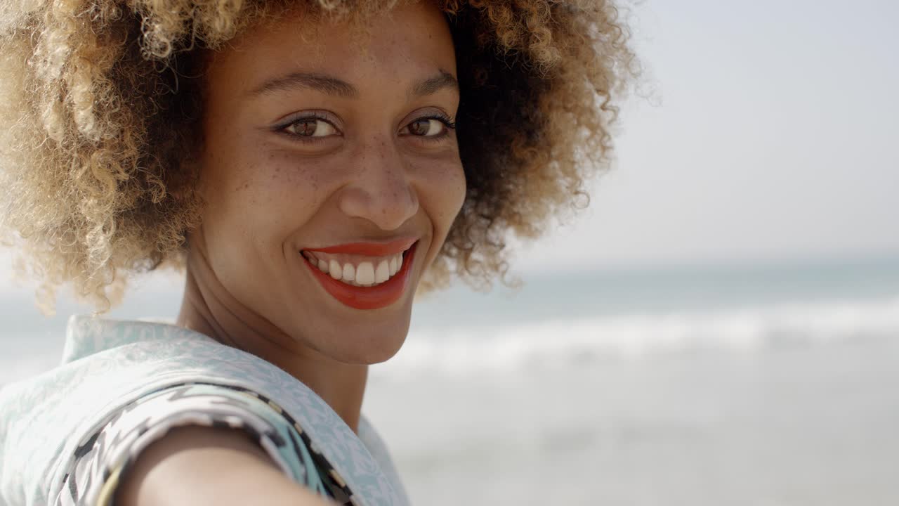 Une femme souriant à la caméra