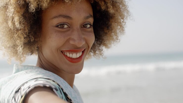 Une femme souriant à la caméra