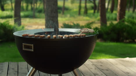 minced meat sticks grilling on grill for bbq party. bowl grade on backyard