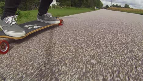 low angle of person riding a longboard on the road