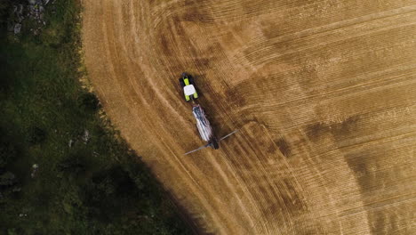 Tracking-following-green-tractor-plowing-field-aerial-from-directly-above-top-down-heavy-work-burden-seeds-hungry-birds-hunting-economy-growth-poor-countries-supply-combine-harvester-pretty-nature-sun