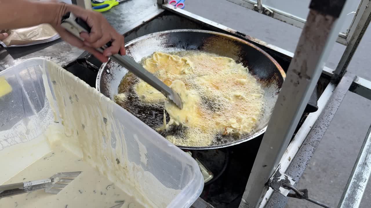 Close-up of Hand Frying Street Food Fritters in Hot Oil