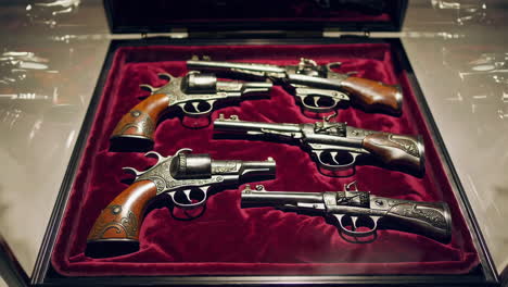 antique pistols and revolvers in a display case