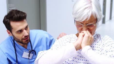 enfermera consolando a una paciente mayor estresada