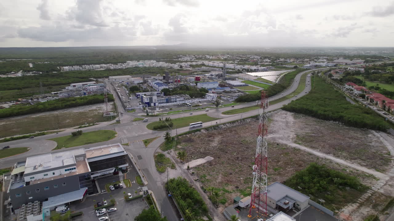 antena junto a la torre del mástil de radio junto a la planta eléctrica cepm y el tráfico pasando por la carretera higuey miches