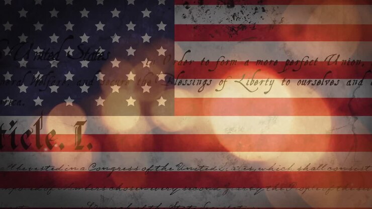 Animation of out of focus glowing sparkles and american constitution text over american flag
