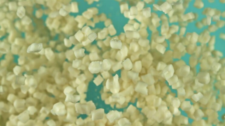 White Sugar Granules Floating in Slow Motion Against a Blue Background