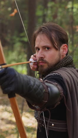 caballero en cadena tira de cuerda de arco en arco en el bosque, juegos de rol históricos, edad media