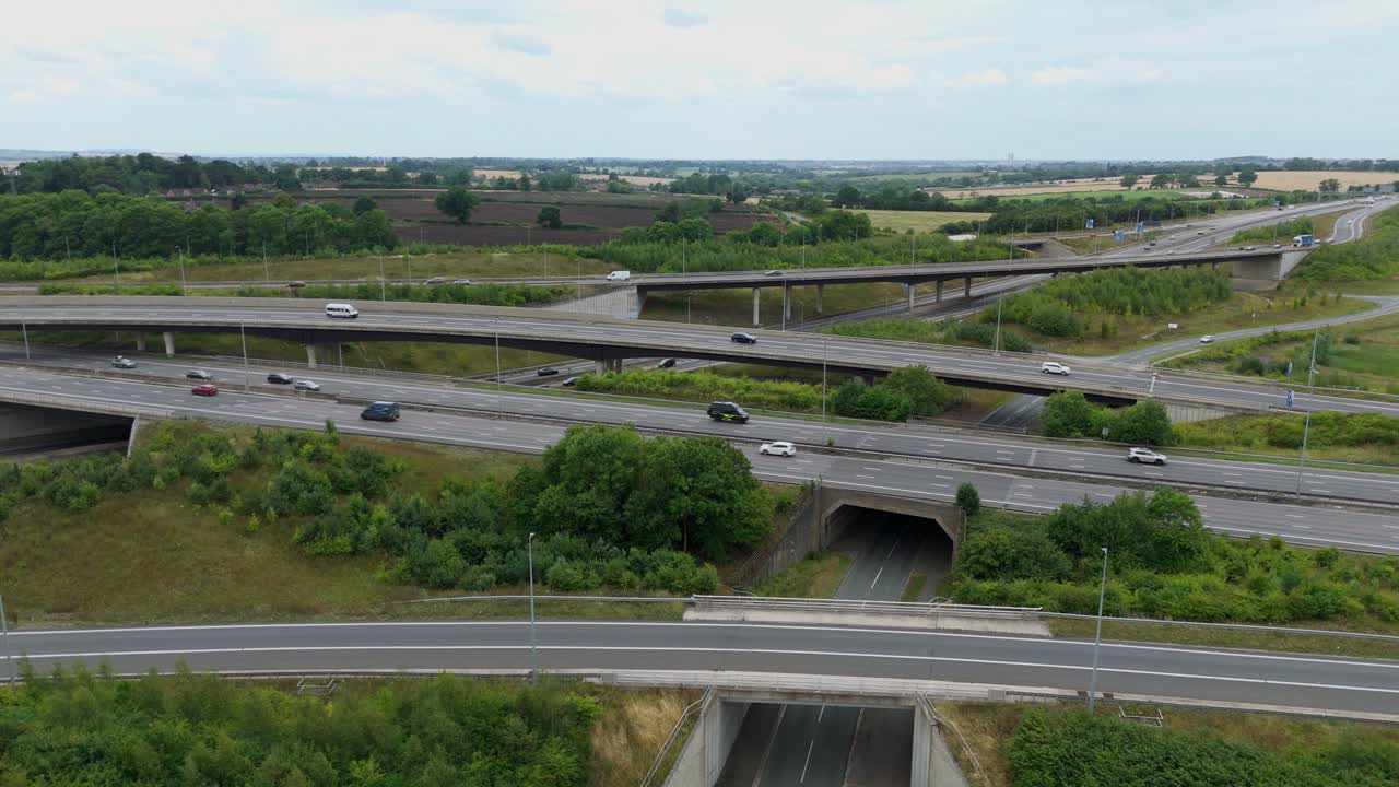 Aerial drone orbiting pan view of busy interchange intersection, lots of traffic travelling along the road near rugby England UK, M1 motorway highway