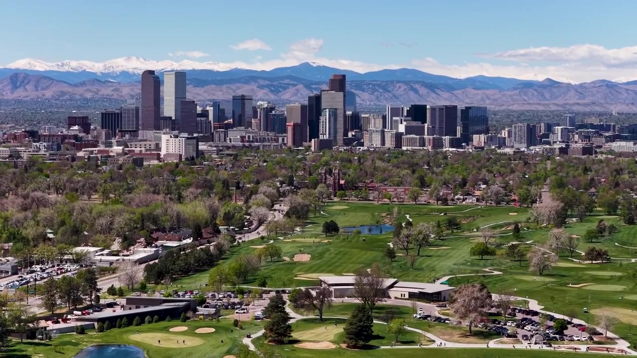Il filmato del drone mostra il campo da golf Denver City Park con lo skyline del centro e le Montagne Rocciose sullo sfondo.