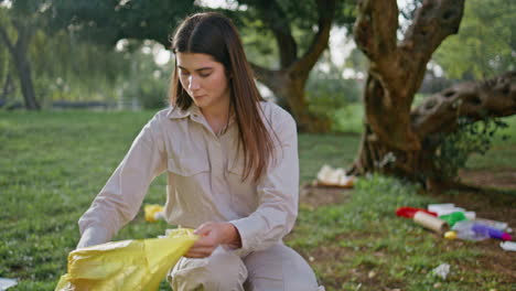 woman conservationist trash collection engaged in environmental cleanup in park.