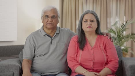 una pareja de ancianos indios enojados mirando a la cámara.