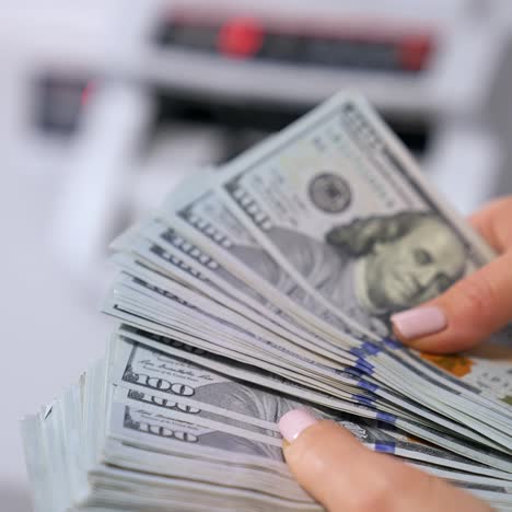 business, finance, saving, banking and people concept - close up of woman hands counting us dollar money