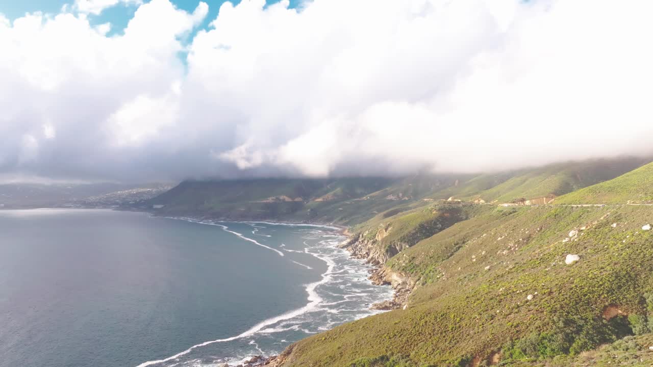 Ripresa aerea drone 4K del paesaggio oceanico e montano di Città del Capo con onde, parallasse panoramico, grandangolo, luce diurna soleggiata e nuvolosa. Perfetto per progetti naturalistici, documentari e d'atmosfera.