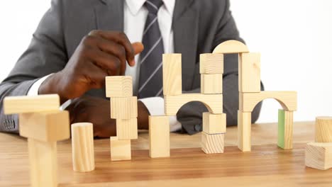 businessman playing with building blocks