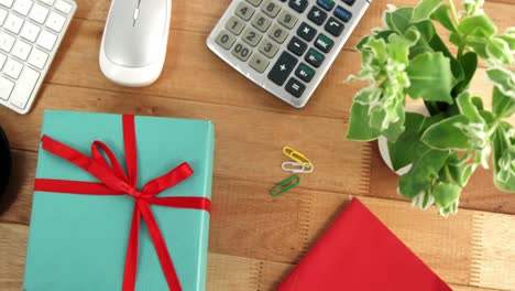 calculadora, caja de regalos, diario, planta en maceta, bolígrafo y taza de café