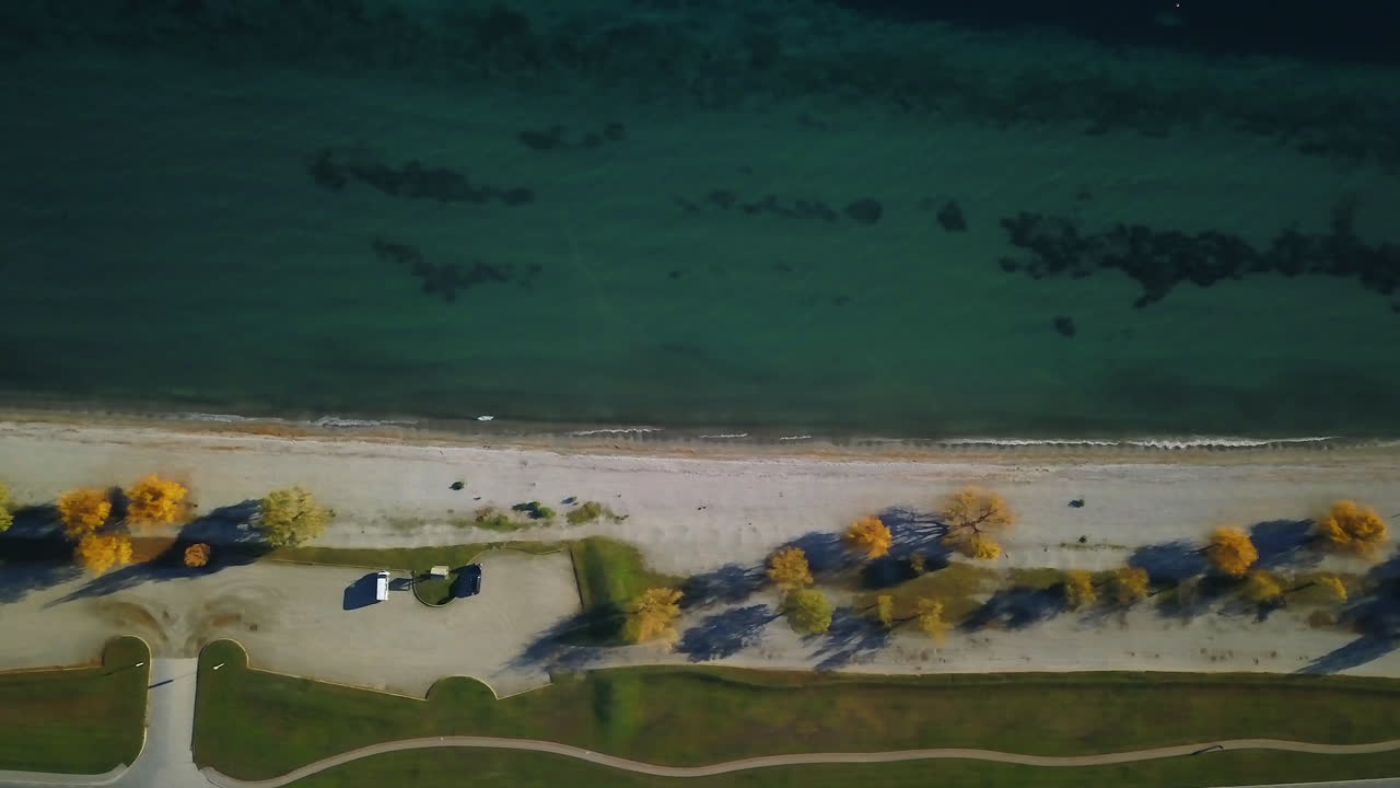 가을날 맑은 와나카 호수의 버드아이 뷰 드론 트럭 운송 샷