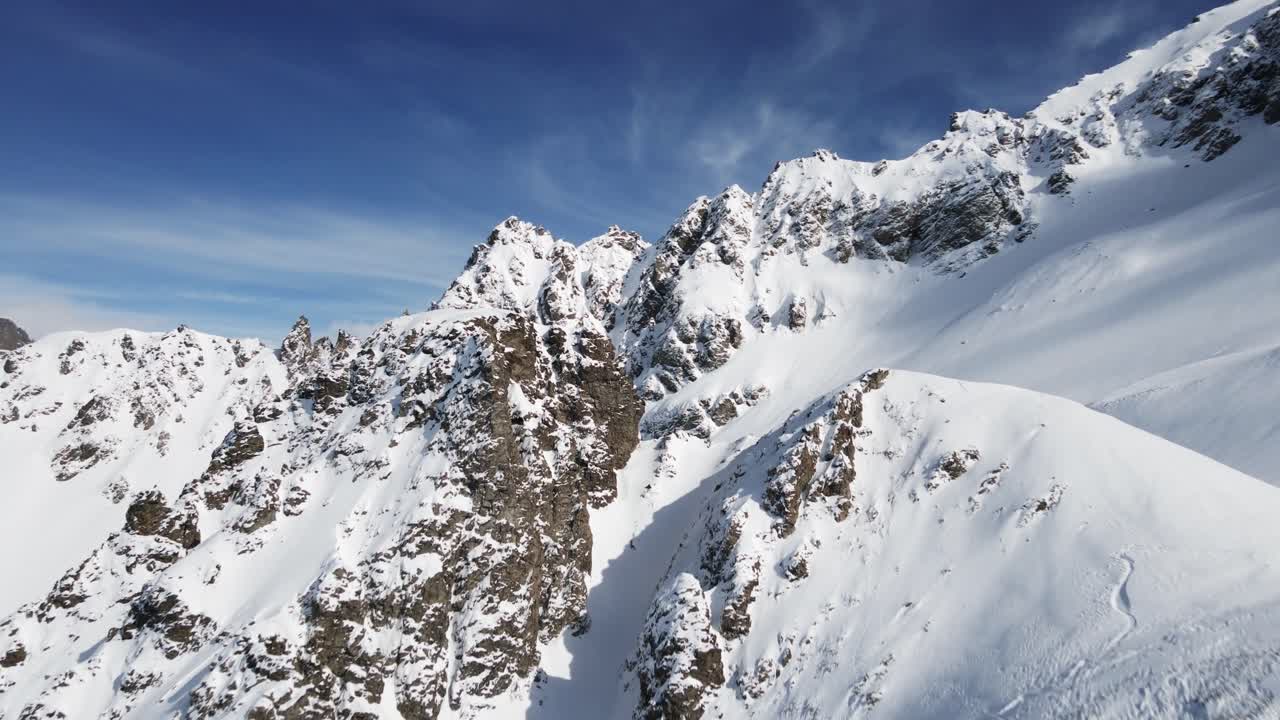 A breathtaking aerial view of snow-covered mountain peaks, showcasing serene alpine landscapes and crisp natural beauty during winter