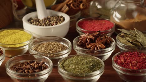 various spices in glass bowls close-up. middle eastern and arabian culture. seasoning and flavors. pepper, coriander, vanilla, turmeric, paprika, cumin. different kinds of dry herbs for cooking.