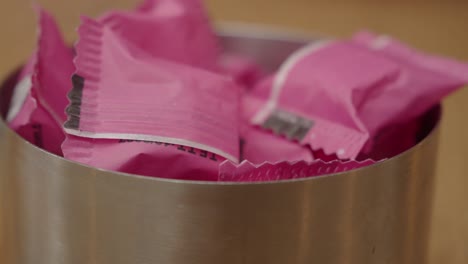 pink sugar packets in a silver container