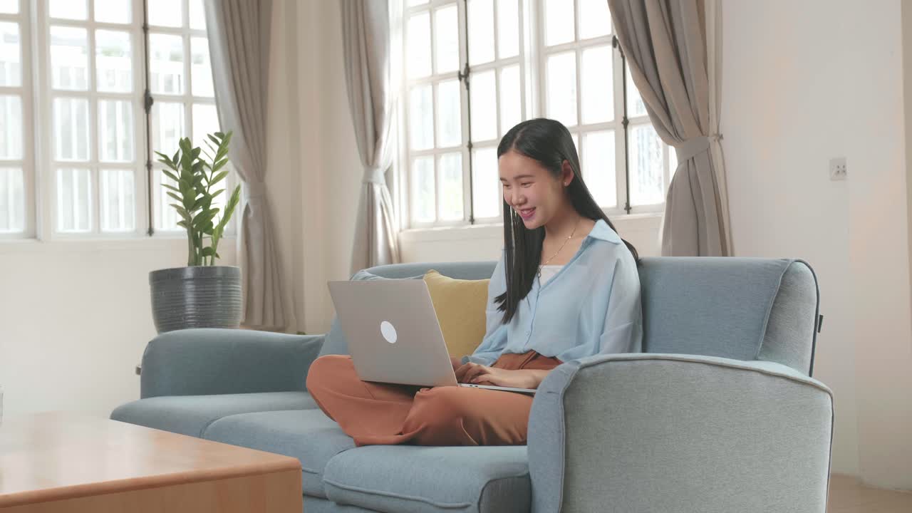 Woman Sitting Sofa And Use Laptop Computer In Home Living Room, Video In 4K