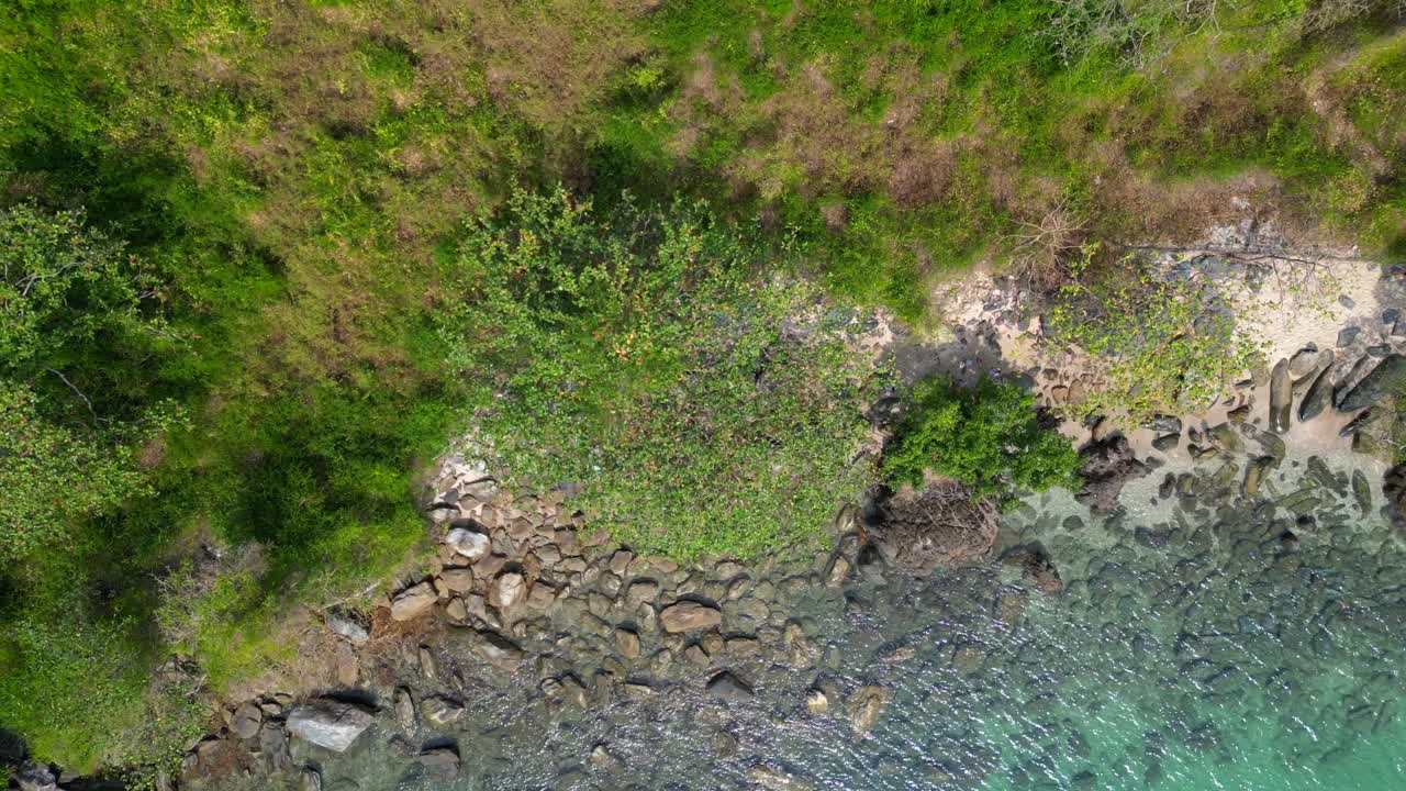 Lush green hills and turquoise waters along Koh Chang's coastline. Majestic aerial view flight drone camera pointing down