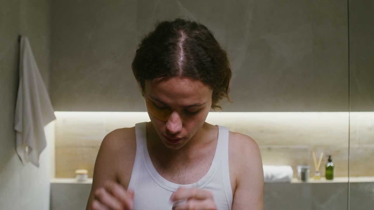 욕실 에서 금색 눈 마스크 를 착용 하는 사람