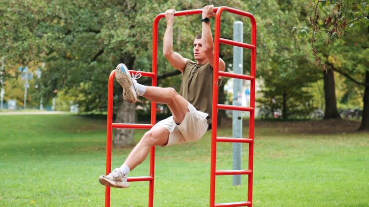 Athletic man training on equipment poles in public park