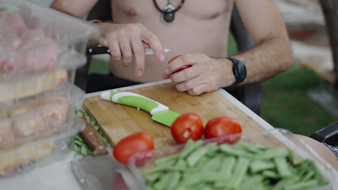 Uomo che prepara verdure e altri ingredienti per cucinare all'aperto