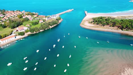 Boote,-Die-An-Einem-Sonnigen-Tag-In-Einem-Wunderschönen-Hafen-Ankern,-Der-Von-Seedeichen-Mit-Blauem-Wasser-Geschützt-Wird