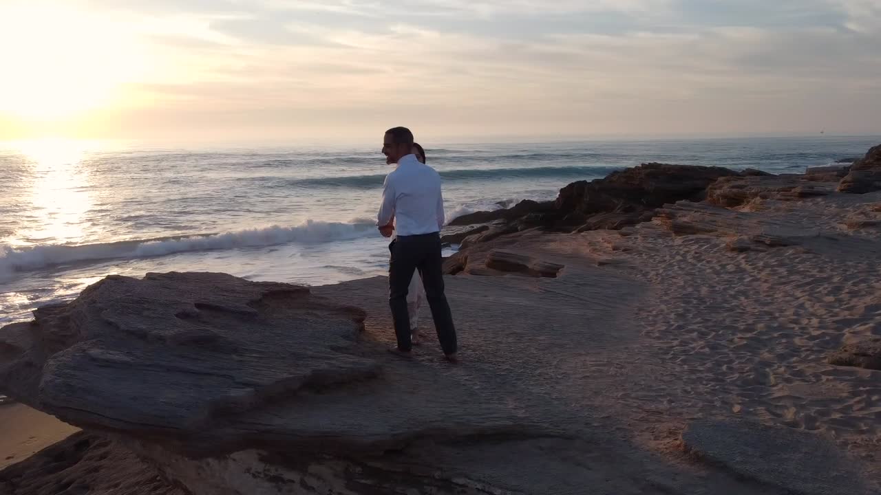 pareja de recién casados besándose en la costa